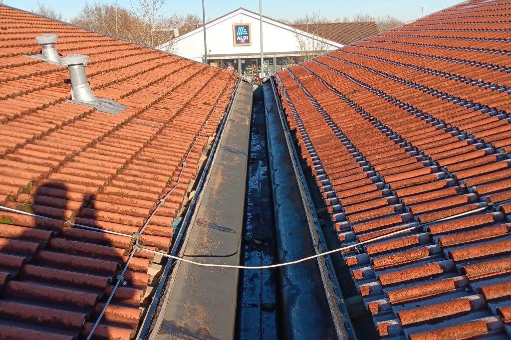 Reinigung der Dachrinne einer Gewerbeimmobilie